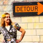 Amy of the Peddler's Post with a Detour sign outback of Trailside Bike in Floral City, FL.