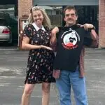 Amy and Mike (December Peddlers Post T-shirt winner) standing in front of Tony's Auto Clinic in Inverness Florida