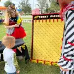Child playing Penny Plinko at the Peddler's Post booth at Cooterween hosted by the Twistid Arts Initiative in downtown Inverness, FL. 2023